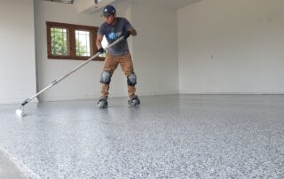 Man concrete coating the garage floor - Types of Concrete Coatings